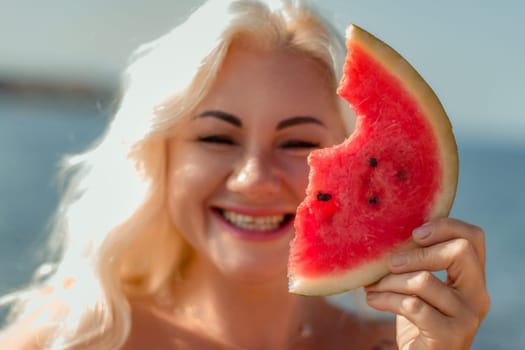 Smiling blonde woman holds a partially eaten slice of watermelon, covering half her face. Summer vibes.