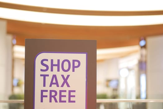 Sign invites shoppers to experience tax-free purchases in a mall.