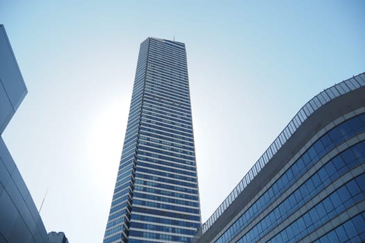 A tall skyscraper showcases modern design against a clear blue sky.