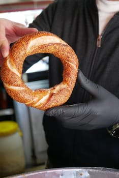 Vendor showcases traditional turkish simit at market stall.