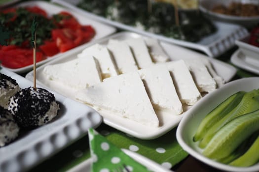 Slices of fresh cheese displayed alongside vibrant vegetables and toppings.