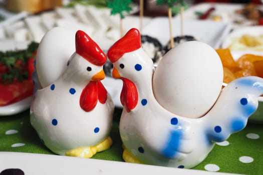 Two charming chicken shakers face each other on a colorful table setting.