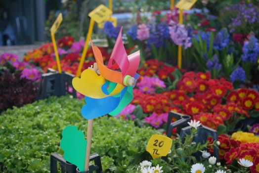 A playful windmill stands out in a flower market bursting with colors.