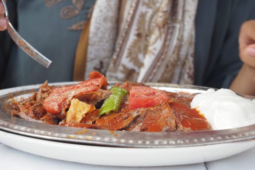 Iskender kebab served alongside yogurt,