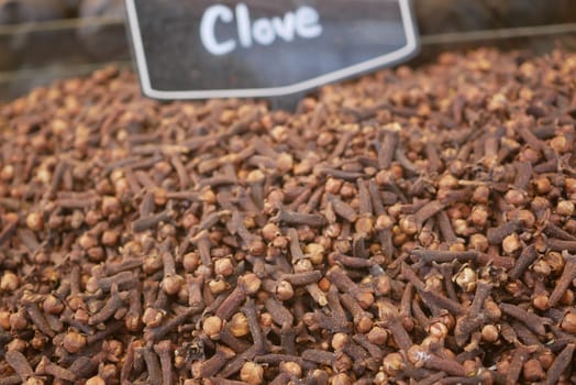 Clove spices are piled high at a marketplace, ready for purchase.
