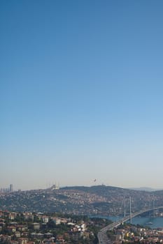 Cityscape shows a bridge and vibrant neighborhoods under blue skies.