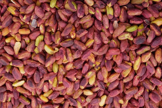 Pistachios in various shades are spread out at a market during autumn.