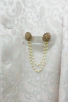 Beautiful gold and pearl embellishments on luxurious white fabric.