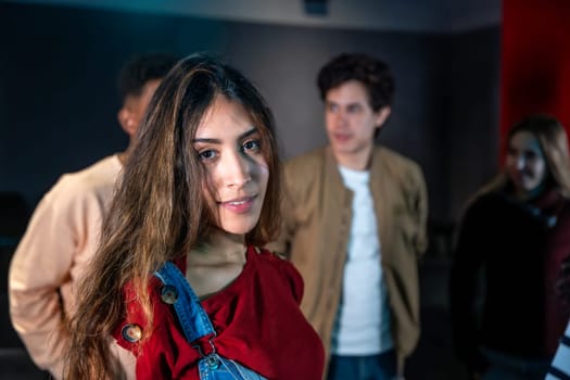 Group of young people enjoying a movie disco dance and event, with a smiling young woman in the foreground