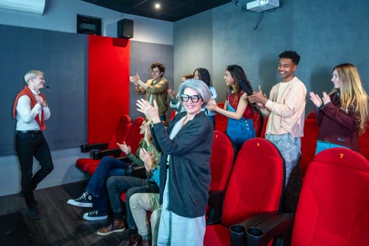 Diverse audience clapping hands after watching a movie presentation in a small cinema, enjoying the show and the company of each other