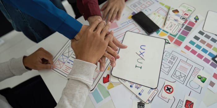 A group of UX UI designers collaborates, sharing ideas and creative concepts. Their unity symbolizes the collaborative spirit essential for innovative design solutions.
