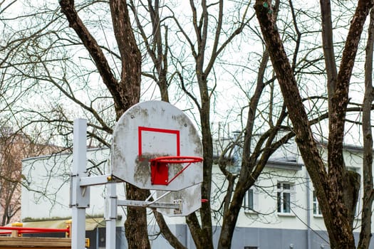 In a peaceful park, a basketball hoop stands tall, surrounded by lush green trees, creating a perfect setting for a game of basketball