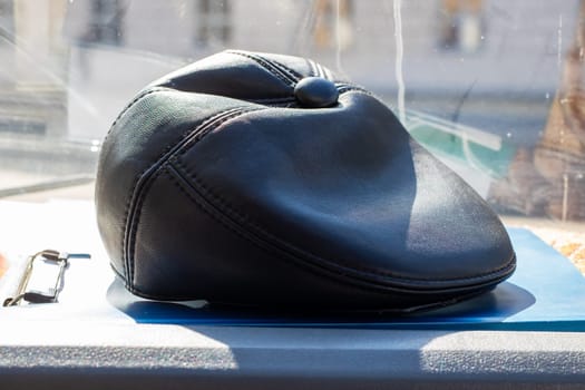 A stylish black hat is carefully positioned on top of a vibrant blue table, adding a striking contrast to the scene around it