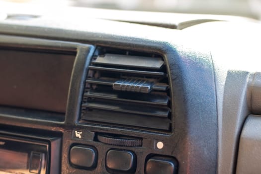 This is a detailed closeup image showcasing a car dashboard that features various buttons and air vents prominently displayed
