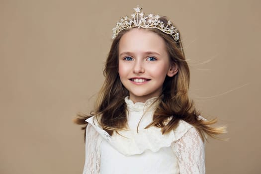 Adorable girl in a crown and white dress, radiating happiness and joy The soft brown backdrop enhances the seasonal celebration theme, ideal for family events or children s parties