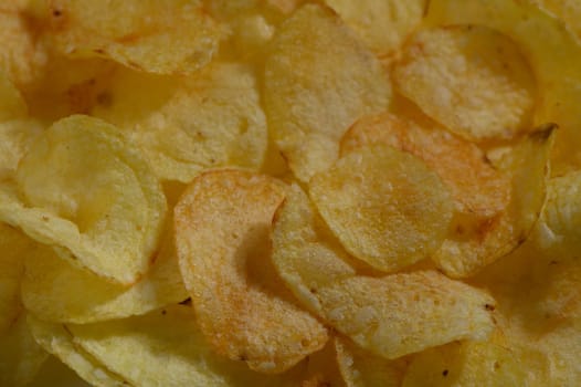 A delicious assortment of crispy potato chips, exhibiting a delightful golden hue, perfect for sharing during a casual gathering or enjoying solo while relaxing at home.