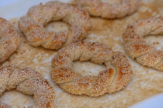 Early morning at a bustling market showcases homemade sesame rings, golden and crisp, inviting passersby to savor their delightful aroma and unique taste.