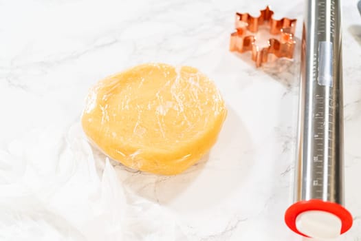 Sugar cookie dough wrapped in plastic wrap, ready for chilling before rolling and cutting