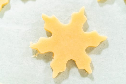 Close-up of a single star shaped sugar cookie cutout on parchment paper, showing the smooth dough surface.