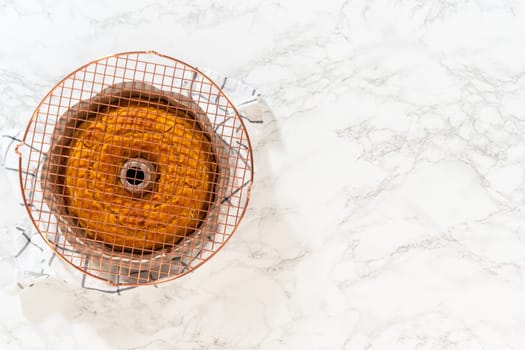 Flat lay. Cooling freshly baked pumpkin bundt cake on the kitchen counter.