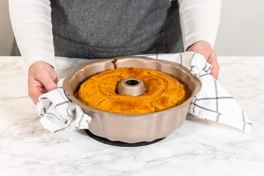 Cooling freshly baked pumpkin bundt cake on the kitchen counter.