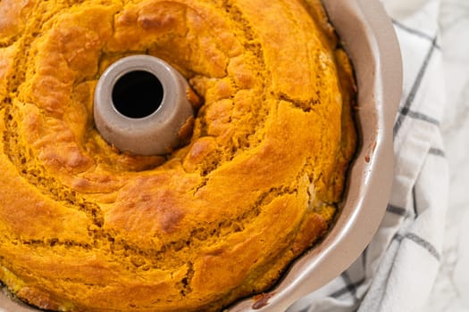 Cooling freshly baked pumpkin bundt cake on the kitchen counter.