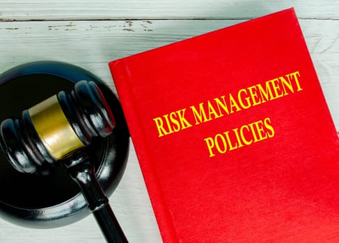 Top view of Risk Management Policies book with gavel background.