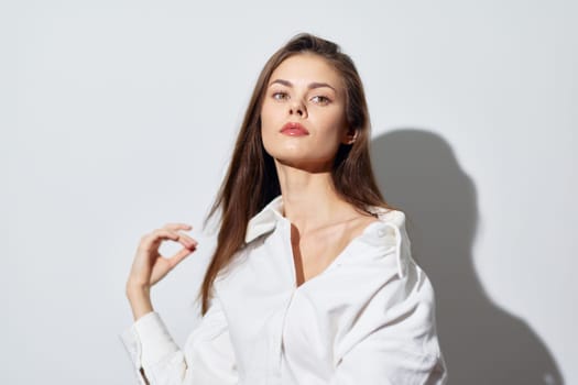 This image features a striking portrait of a young woman with long, flowing hair, dressed in a crisp white shirt The soft lighting highlights her facial features and creates a serene atmosphere Set