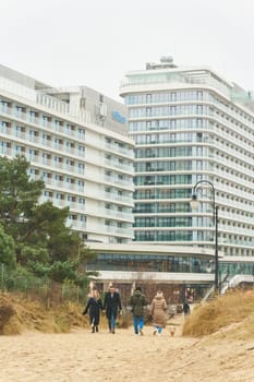 Swinoujscie, Poland – December 26, 2024: Hotels and some vacationers on the beach of Swinoujscie, Swinemunde on the Polish Baltic Sea coast