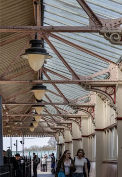 Windsor, England - Apr 3, 2025 - Passengers relaxed waiting for the train on the platform at Windsor & Eton Central. A vintage canopy and lamps, Travel photography. Lifestyle, use it as your Wallpaper, Poster and Copy space, Selective focus.