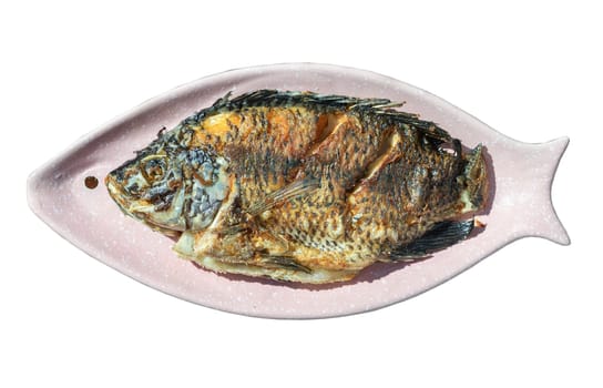 Top view of Delicious deep fried Whole tilapia fish on Ceramic fish plate isolated on white background with clipping path. Selected focus.