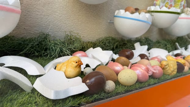 28.03.2025 Innsbruck: Decorative Easter Scene Featuring Chicks, Eggs, and Grass Display. Colorful decorative setup with vibrant eggs, chicks, and broken shells, arranged on green grass, symbolizing Easter celebration and springtime joy.