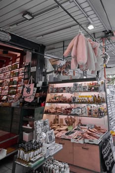 Crete, Greece - April 5, 2025: Neatly arranged souvenir shop with natural sponges, wooden kitchenware, oils, and spices, surrounded by postcards and decorative Mediterranean crafts.