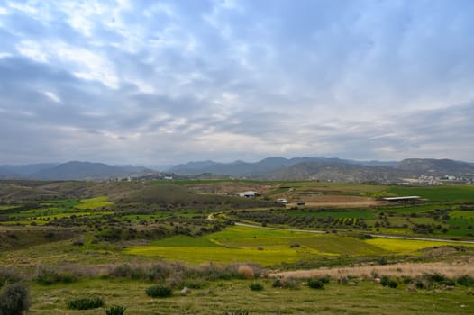 Rolling green hills create a picturesque view as soft clouds drift overhead during the late afternoon. The tranquil countryside invites peaceful reflection and exploration of nature's beauty.