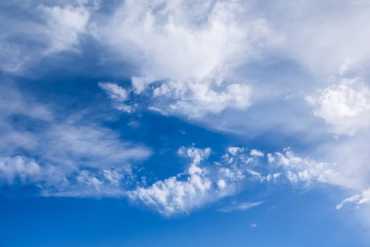 Beautiful white clouds gently float across a deep blue sky, creating a serene and picturesque scene