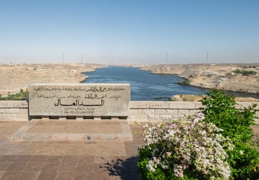 Aswan, Egypt - 4 November 2024: View down the sloping side of the Aswan Dam in Egypt at the river Nile with commemorative stone