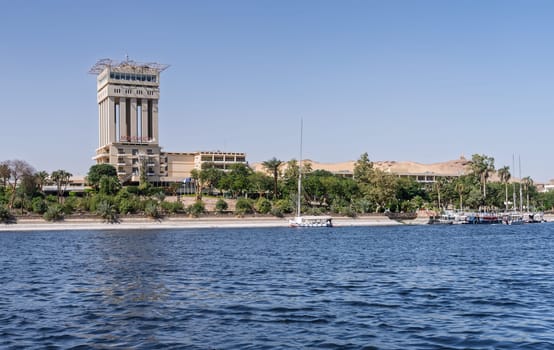 Aswan, Egypt - 4 November 2024: Movenpick Hotel in Elephantine, by the Nile. Felluca docked by the resort