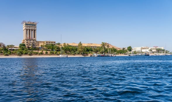 Aswan, Egypt - 4 November 2024: Movenpick Hotel in Elephantine, by the Nile. Felluca docked by the resort