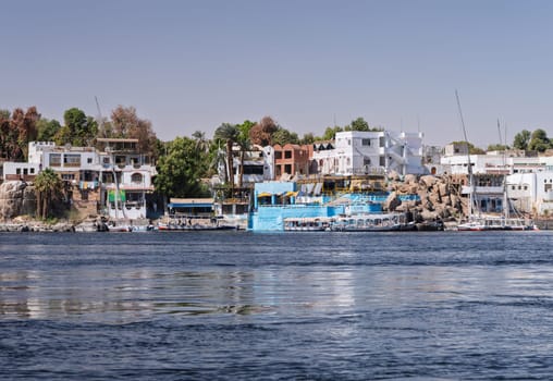Aswan, Egypt - 4 November 2024: Bars and restaurants including King Jamaica line the shores of Nile with ferry boats