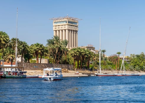 Aswan, Egypt - 4 November 2024: Movenpick Hotel in Elephantine, by the Nile. Felluca docked by the resort