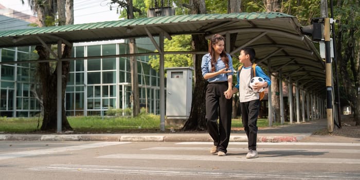 As they pause to cross the street, the mentor encourages the boy, reinforcing the importance of physical activity and friendship after school.