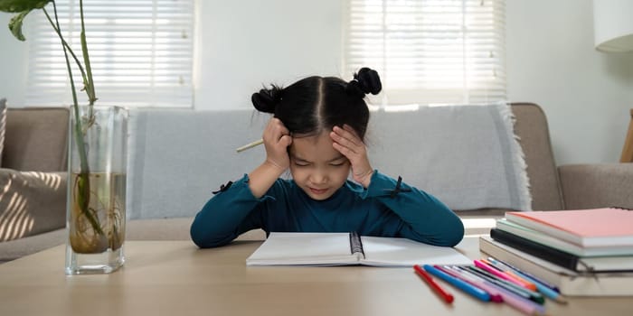 A young girl sits at a table, visibly frustrated as she struggles to complete her homework. This image captures the challenges kids face in their learning journey.