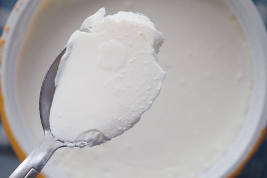 A spoon holds smooth and creamy yogurt ready to be enjoyed.