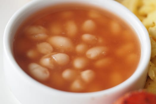 Hearty white beans in a rich broth accompany flavorful rice on the plate.