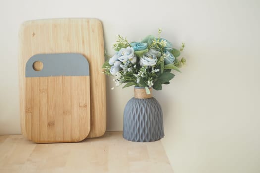 Stylish arrangement of cutting boards alongside a floral vase at home.