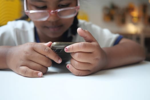 Child engaged in smartphone activity with concentration and intention.