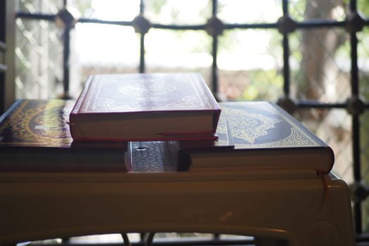 quran resting on a small table in a mosque .