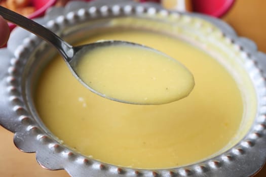 Creamy custard being served from a decorative bowl at a festive gathering.