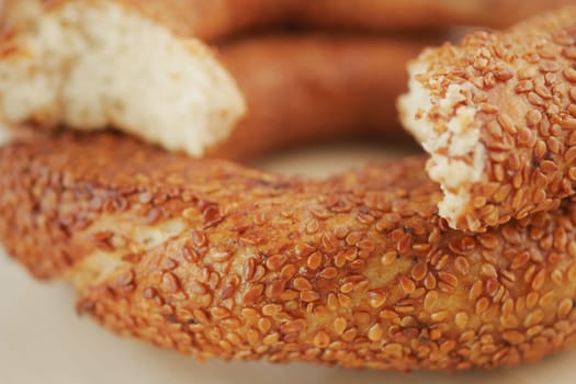 Delicious sesame bread rings displayed on a plate at a bakery shop.