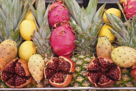 Vibrant assortment of tropical fruits including pineapples and dragon fruits.